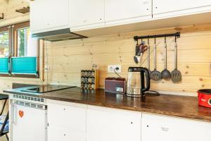 a kitchen with white cabinets and a counter top at Tiny House Evita in Lehnin