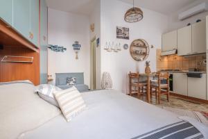 a bedroom with a white bed and a kitchen at Tyndaris home in Oliveri