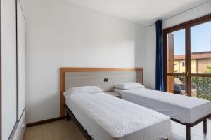 a hospital room with two beds and a window at Casa Vacanze da Ricky App 5 in Peschiera del Garda +16 photos