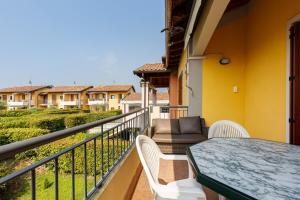 a balcony with a table and chairs and a couch at Casa Vacanze da Ricky App 5 in Peschiera del Garda