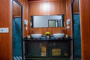a bathroom with two sinks and a mirror at Savor Hostel-Motorbike Rental-Tour in Làng Lap +46 photos