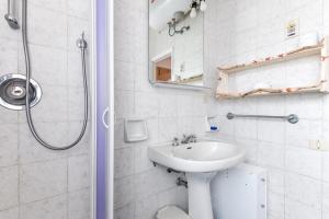 a white bathroom with a sink and a shower at Villetta Serena in Procchio