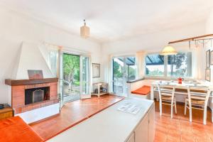 a kitchen and living room with a fireplace and a table at Villetta Serena in Procchio