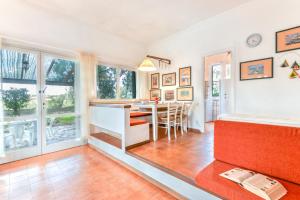 a kitchen and dining room with a table and chairs at Villetta Serena in Procchio +16 photos