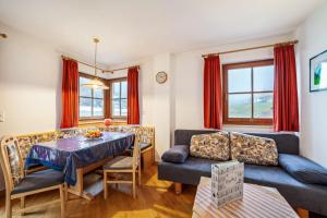 a living room with a couch and a table at Rieglhof Apartment Maisel in Curon Venosta