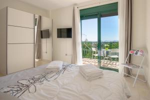 a white bedroom with a bed and a balcony at Duplex vista mar in Yaiza