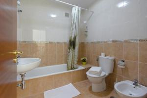 a bathroom with a sink and a toilet and a bath tub at Duplex vista mar in Yaiza +18 photos