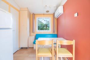 a dining room with orange walls and a table and chairs at Falaguera Bungalow 3 in Bárig