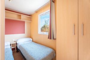 a small room with two beds and a window at Falaguera Bungalow 3 in Bárig +20 photos