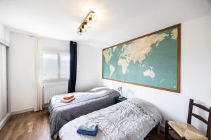 a room with two beds and a map on the wall at Chalet Les Tourelles in Aix-les-Bains