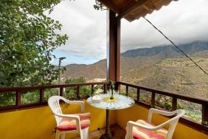 a table and chairs on a balcony with a view at Casa Claudia in Hermigua