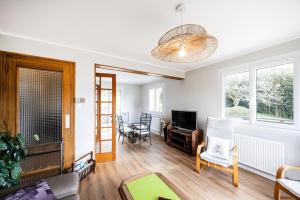 a living room with a couch and a tv at Chalet Les Tourelles in Aix-les-Bains