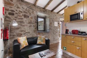 a living room with a couch and a stone wall at Recanto d'Aldeia in Alcoutim