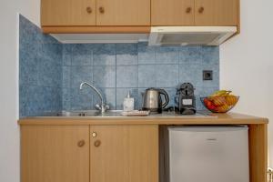 a kitchen with a sink and a refrigerator at Seaview Double Room Private Jacuzzi in Santorini +28 photos