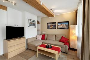a living room with a couch and a flat screen tv at Ciasa Irene Dreizimmerwohnung in La Villa