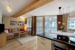 a kitchen and living room with a couch at Ciasa Irene Dreizimmerwohnung in La Villa