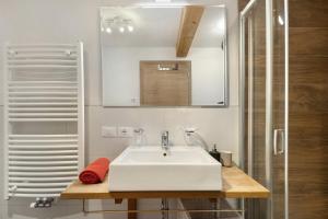 a bathroom with a white sink and a shower at Ciasa Irene Dreizimmerwohnung in La Villa +20 photos