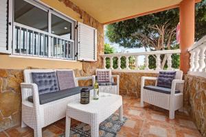 a patio with wicker chairs and a table with a table at Apartamento 7 dioses in Puerto del Rosario