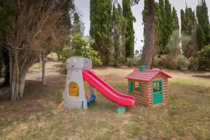 a small playground with a slide and a house at Villa I Tigli - Pervinca in Campiglia Marittima