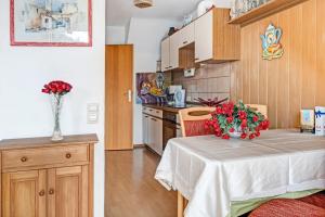 a small kitchen with a table with flowers on it at Reichenaublick in Allensbach +18 photos