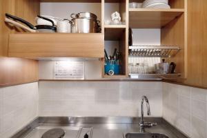 a kitchen with a stainless steel sink and wooden cabinets at Appartamento Bilocale Moneglia 32 in Moneglia
