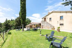 a yard with benches in front of a house at Masseria del bosco Poderuccio in Chianciano Terme