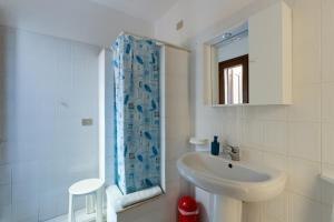 a white bathroom with a sink and a mirror at Villa del Maestro in Narbolia +22 photos