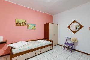 a bedroom with a bed and a purple chair at Villa del Maestro in Narbolia