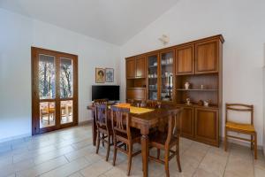 a dining room with a wooden table and chairs at Villa del Maestro in Narbolia