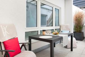 a table and chairs on a patio with a window at Spawo mit Sauna und Whirpool in Pfullendorf +29 photos
