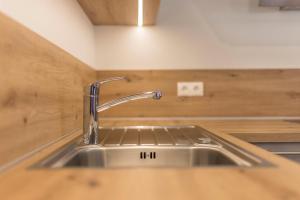 a kitchen sink with a faucet on a counter at Lechnerhof Murmeltier in Valles +22 photos