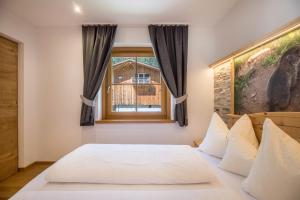 a bedroom with a bed and a window at Lechnerhof Murmeltier in Valles