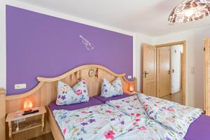 a bedroom with purple walls and a bed with pillows at Ferienwohnung Amethyst in Mittenwald