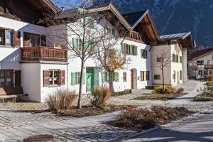 a large white building with a tree in the courtyard at Ferienwohnung Amethyst in Mittenwald +12 photos