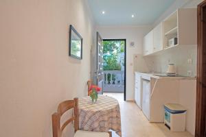 a kitchen with a table with a vase of flowers on it at Andromaches sea view studio 2 in Corfu