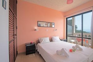 a bedroom with a bed and a large window at Andromaches sea view studio 2 in Corfu +12 photos