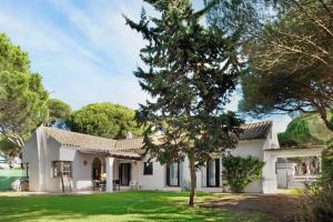 a white house with a tree in the yard at El Mirlito in Roche