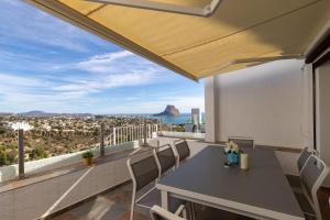 a table and chairs on a balcony with a view of the city at Villa Sol y Mar in Calpe