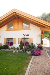 a house with flowers in the front yard at Alfio's Alpen Suite in Roncone