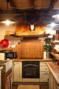 a kitchen with white cabinets and a stove top oven at Alfio's Alpen Suite in Roncone