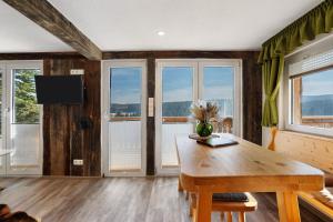 a room with a wooden table and some windows at Ferienhaus Fenzl in Johanngeorgenstadt