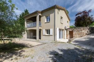 an external view of a house with a stone wall at Le Serre Du Puech in Chambonas