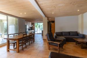 a living room with a couch and a table and chairs at Le Serre Du Puech in Chambonas