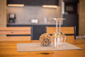 a wine glass and a pine cone on a table at Chalets Reisnock - Hochgruberhof in Selva dei Molini +13 photos