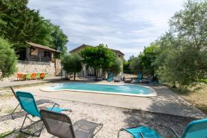 a swimming pool with chairs and a house at Le Serre Du Puech in Chambonas