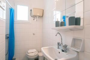 a white bathroom with a sink and a toilet at Livadia Seaside Studios 10 in Parikia +36 photos