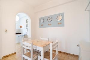 a white dining room with a white table and chairs at Livadia Seaside Studios 10 in Parikia
