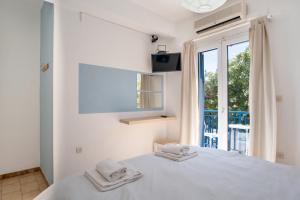 a white bedroom with a bed with towels on it at Livadia Seaside Studios 10 in Parikia