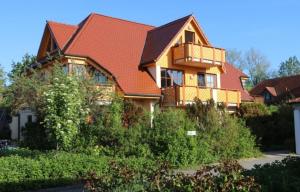 a house with a red roof and a balcony at Oewern Diek in Wustrow