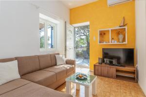 a living room with a couch and a tv at Margaret House in Parikia